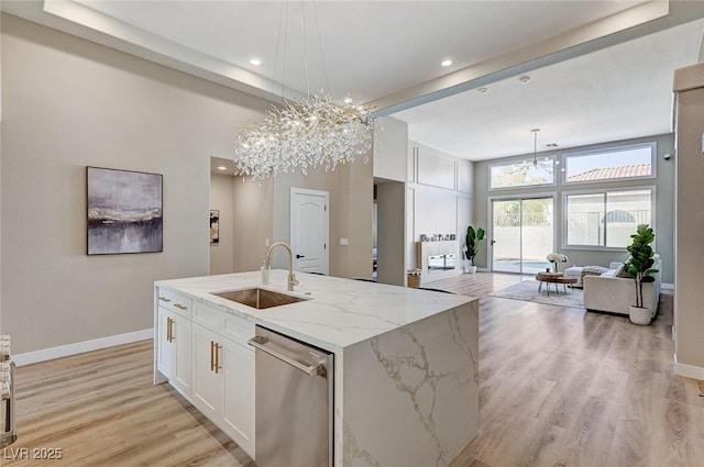 kitchen featuring white cabinets, dishwasher, light wood-type flooring, a chandelier, and a sink