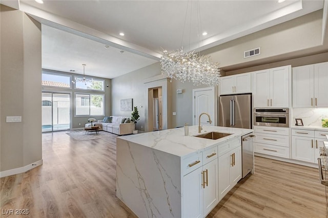 kitchen featuring a chandelier, a sink, visible vents, white cabinets, and appliances with stainless steel finishes