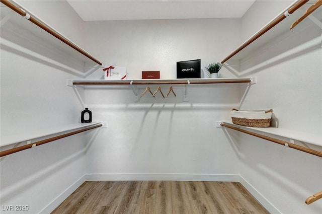 walk in closet with light wood-style floors