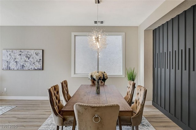 dining space with baseboards, visible vents, and light wood-style floors