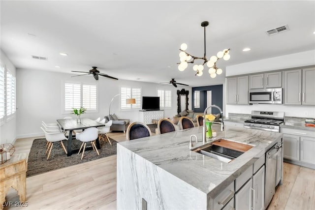 kitchen featuring gray cabinetry, visible vents, appliances with stainless steel finishes, and a sink