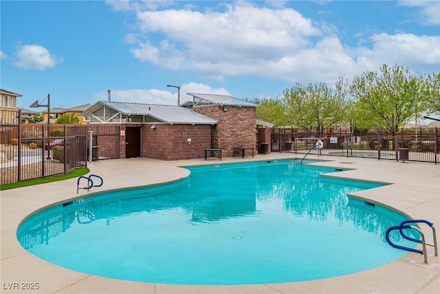 pool with a patio area and fence