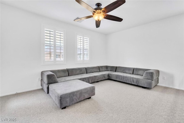 living area featuring carpet flooring, ceiling fan, and baseboards