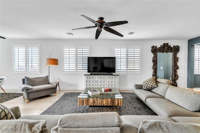 living room with a ceiling fan, wood finished floors, visible vents, and baseboards