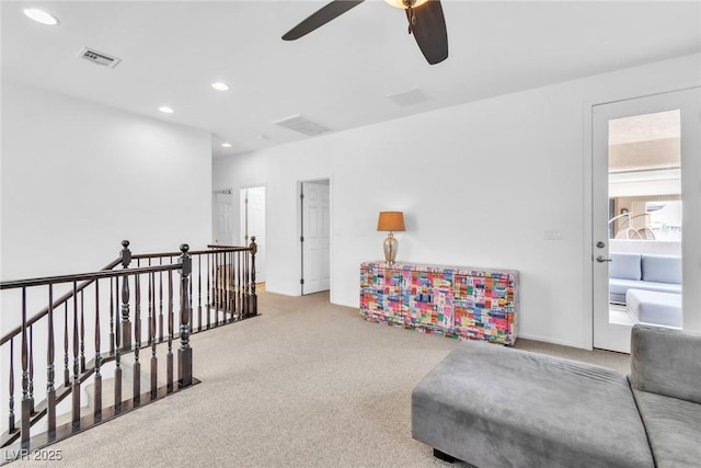 living area featuring recessed lighting, carpet, visible vents, and an upstairs landing