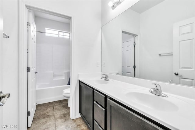 full bathroom with double vanity, tile patterned floors, toilet, and a sink