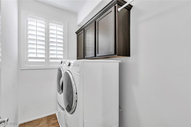 washroom featuring cabinet space, separate washer and dryer, and baseboards