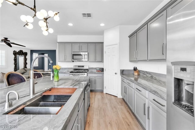 kitchen featuring a sink, stainless steel appliances, gray cabinetry, and visible vents