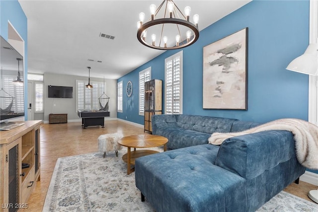 tiled living area featuring an inviting chandelier, visible vents, and baseboards