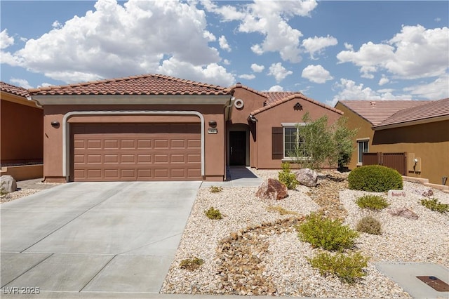 mediterranean / spanish house featuring concrete driveway, an attached garage, a tiled roof, and stucco siding