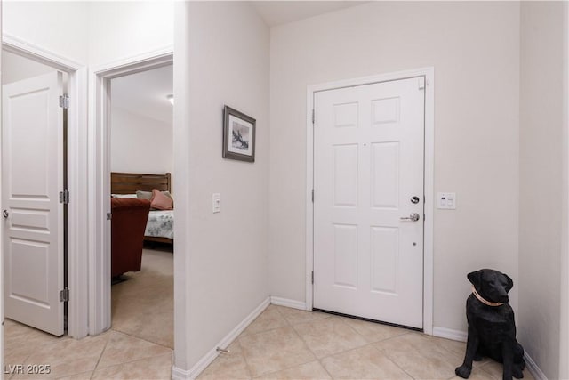 foyer with light tile patterned floors and baseboards