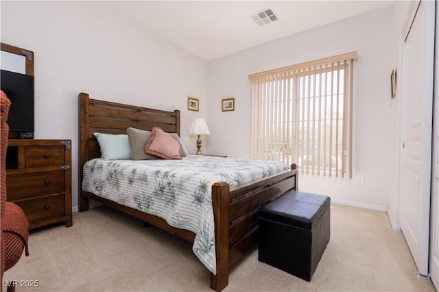 bedroom with baseboards, visible vents, and light colored carpet