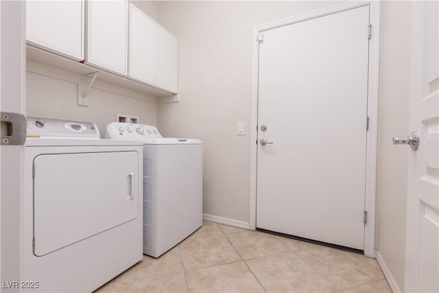 washroom with cabinet space, light tile patterned floors, baseboards, and independent washer and dryer