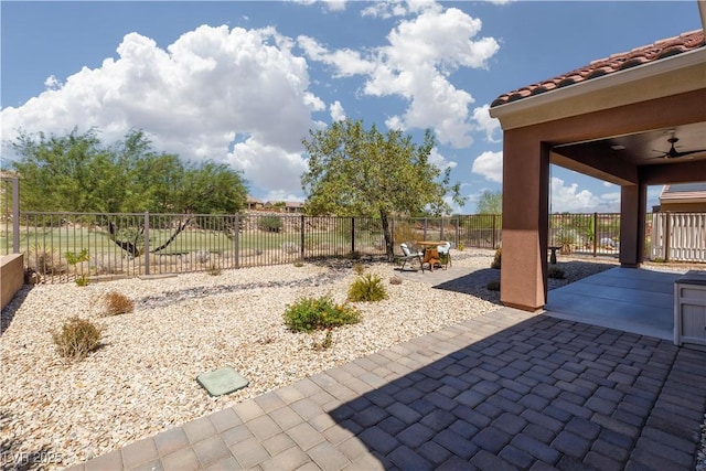 view of patio with a fenced backyard and a ceiling fan