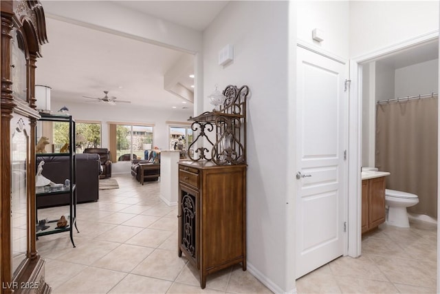 hall featuring recessed lighting, light tile patterned flooring, and baseboards