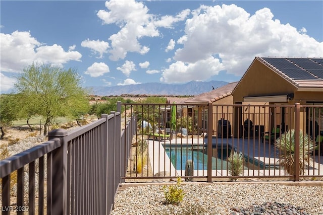 view of pool with a patio, fence, a mountain view, and a fenced in pool