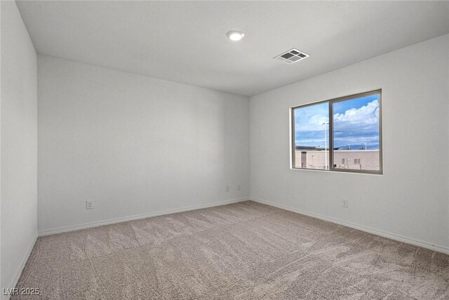 unfurnished room featuring baseboards, visible vents, and carpet flooring