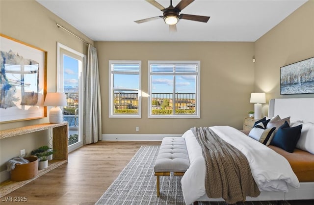 bedroom featuring baseboards, wood finished floors, and a ceiling fan