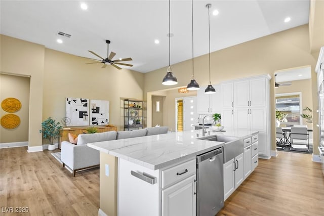 kitchen with light wood-style flooring, dishwasher, a center island with sink, and white cabinets