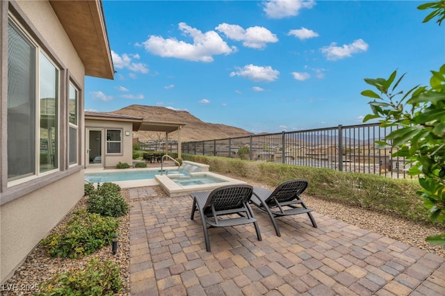 view of patio / terrace with a fenced in pool, an in ground hot tub, and a fenced backyard