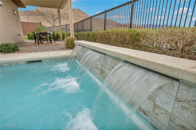 view of pool featuring a patio area, a mountain view, fence, and a fenced in pool