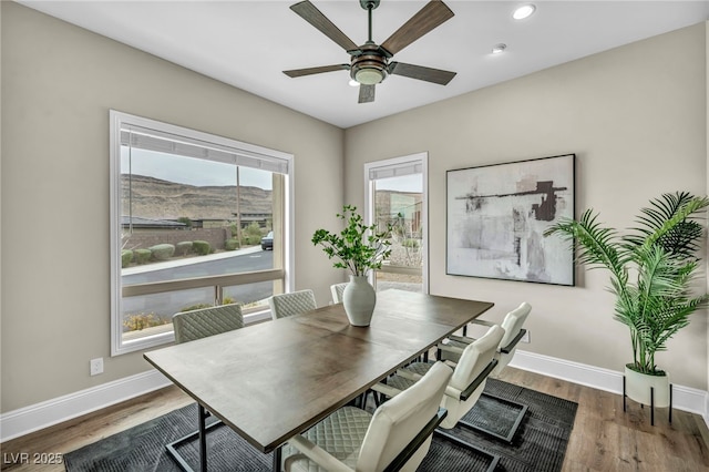 dining space featuring wood finished floors, recessed lighting, a mountain view, baseboards, and ceiling fan