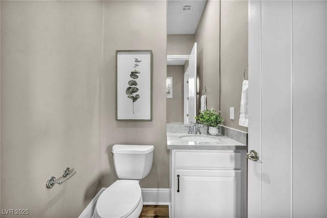 bathroom with visible vents, baseboards, toilet, and vanity