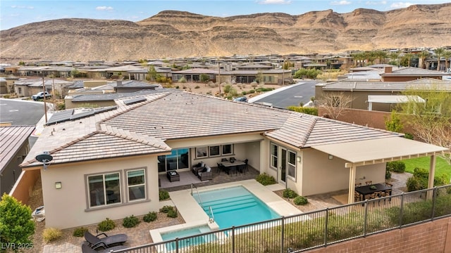 back of house featuring a patio area, a residential view, stucco siding, and a fenced backyard