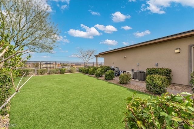 view of yard with central AC and fence