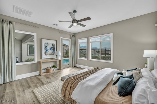 bedroom with access to exterior, visible vents, light wood-style flooring, and baseboards