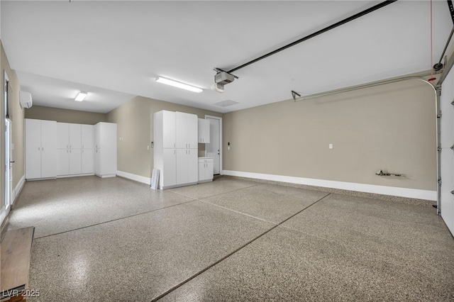 garage with baseboards, an AC wall unit, and a garage door opener