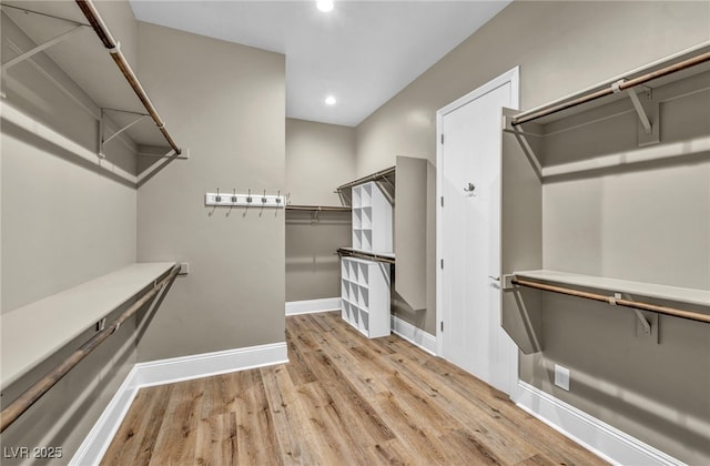 walk in closet with wood finished floors