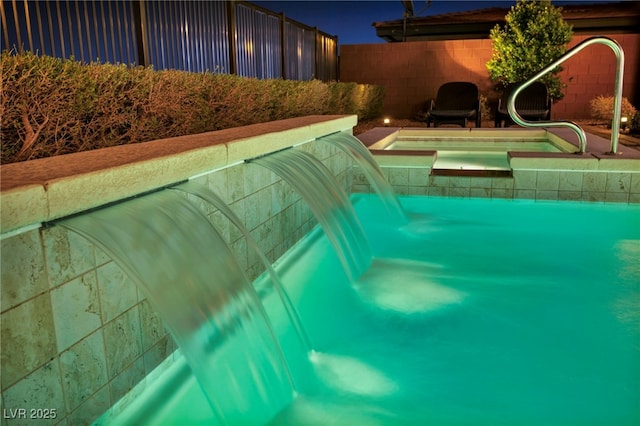 view of pool with an in ground hot tub and a fenced backyard