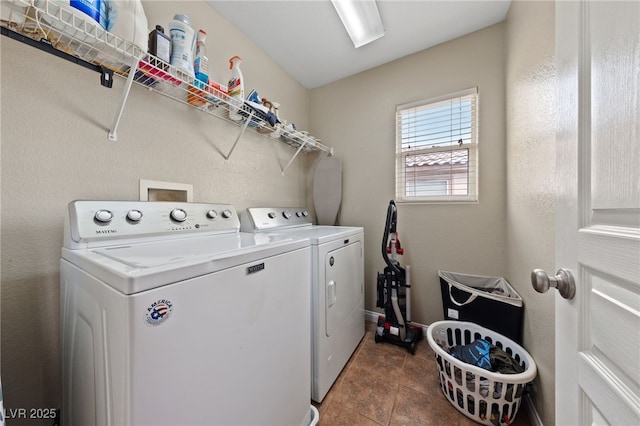 laundry area with laundry area, washer and clothes dryer, and tile patterned flooring