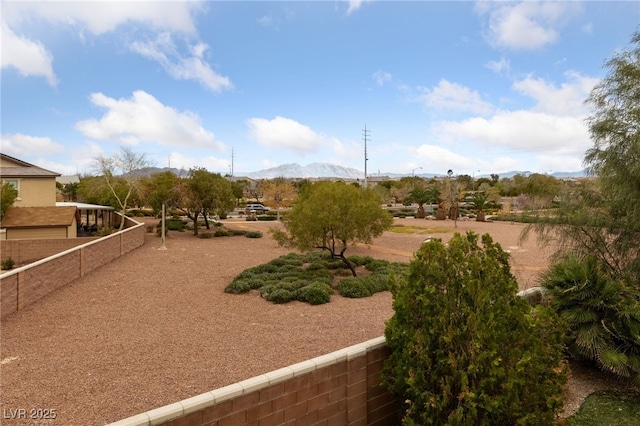 view of home's community featuring fence and a mountain view