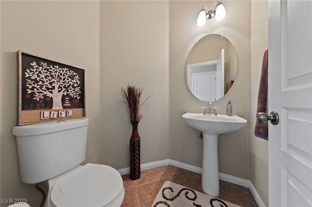 bathroom with baseboards, toilet, and tile patterned floors