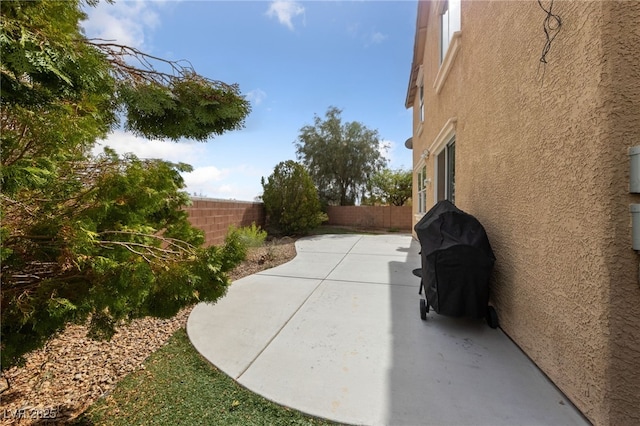 view of patio with grilling area and a fenced backyard