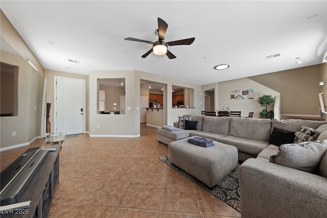 living area with light tile patterned flooring, visible vents, and baseboards