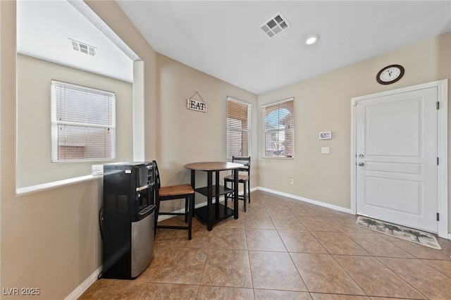 foyer entrance featuring visible vents, baseboards, and light tile patterned flooring