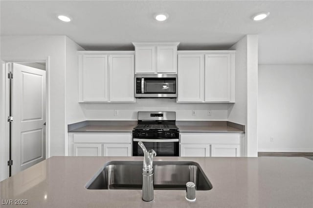 kitchen featuring appliances with stainless steel finishes, recessed lighting, a sink, and white cabinets