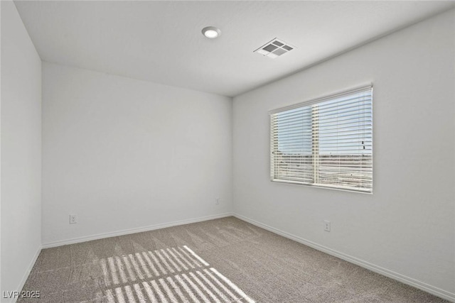 spare room featuring carpet, visible vents, and baseboards