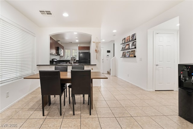 dining area featuring arched walkways, light tile patterned flooring, visible vents, and recessed lighting