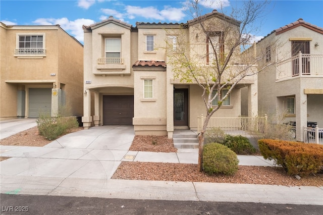 view of front of house with a garage, concrete driveway, a tiled roof, and stucco siding