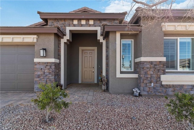 property entrance featuring a garage, stone siding, and stucco siding