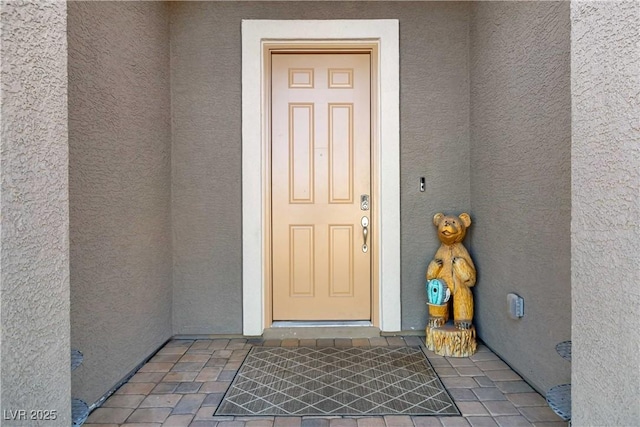 view of exterior entry featuring stucco siding