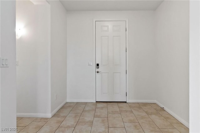 unfurnished room featuring light tile patterned floors and baseboards