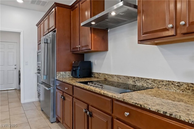 kitchen with light tile patterned flooring, black electric cooktop, high end refrigerator, visible vents, and wall chimney range hood