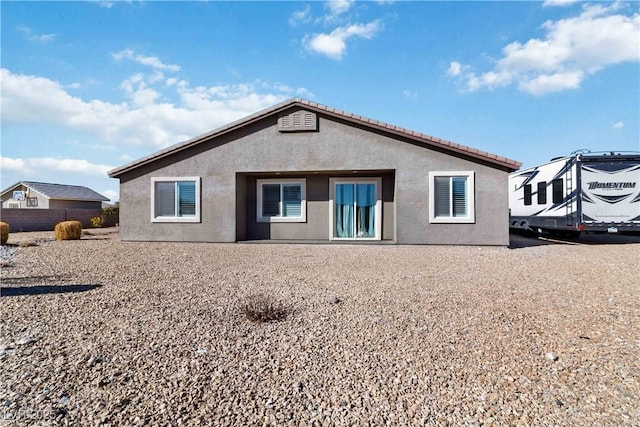 rear view of property featuring stucco siding