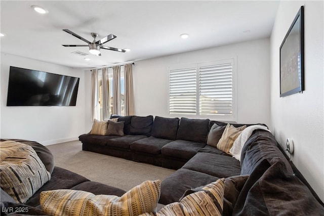 carpeted living area with a ceiling fan, a wealth of natural light, visible vents, and baseboards