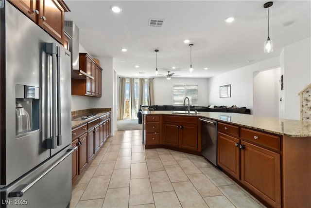 kitchen with visible vents, appliances with stainless steel finishes, open floor plan, hanging light fixtures, and a sink